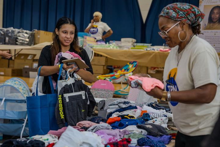 A TPN volunteer helping a young mom choose baby clothes
